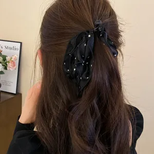 Vista dettagliata di un fermaglio per capelli in tessuto a pois neri su capelli castani