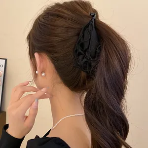 Dettaglio ravvicinato di un elegante fermaglio per capelli in tessuto nero a forma di fiore
