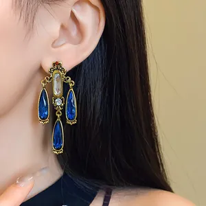 Detailed view of vintage palace style earrings with blue water drop tassels
