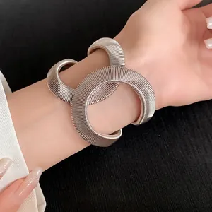 Llamativa pulsera elástica de bobina plateada con diseño cruzado de vanguardia