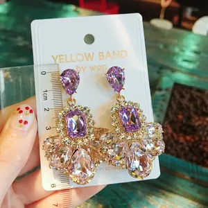 Detail view of luxury purple crystal teardrop earrings measured with a ruler for size accuracy.