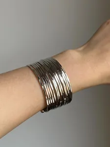 Close-up of silver multi-layer metallic cuff bracelet with hammered texture details