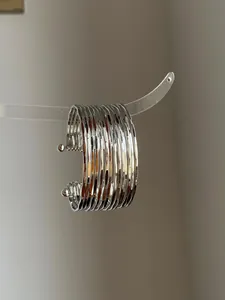 Detailed macro view of elegant silver metallic wrinkled multi-layer open cuff bracelet.