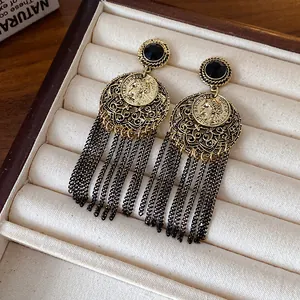 Detailed view of vintage style hollow round dangle earrings featuring long black chain tassels