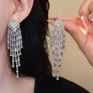 Close-up of elegant gold-plated zircon tassel earrings with sparkling stone drops for women