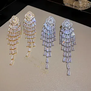 Macro view of luxurious gold and silver tassel earrings featuring brilliant zircon stones