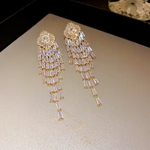 Detailed macro view of elegant gold-plated tassel earrings with clear zircons