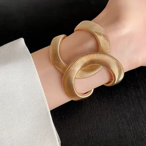 Vista detallada de un brazalete de serpiente dorado grueso con diseño de puño elástico.