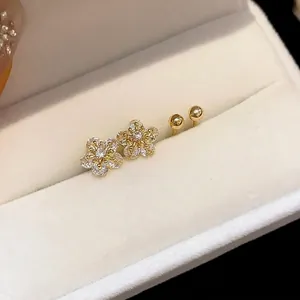 Elegant gold flower stud earrings featuring zircon crystals presented in a white gift box