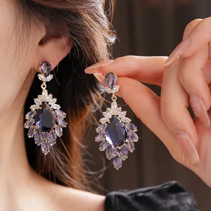Dettaglio di orecchini vintage con cristalli viola e riflessi eleganti e lussuosi