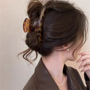 Side view of a large vintage tortoiseshell hair claw clip styled on thick brown hair