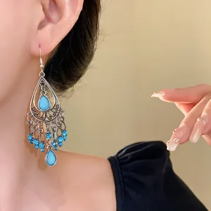Eleganti orecchini a nappa bohémien vintage con strass blu indossati da una modella