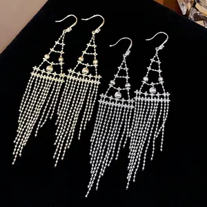 Pendientes largos geométricos con borlas y circonitas en acabado dorado y plateado.
