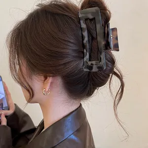 Close-up showing a large leopard print tortoiseshell claw clip on long brown hair