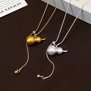 Detailed macro view of brushed gourd pendant necklaces on adjustable golden and silver snake chains