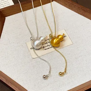 Close-up of brushed metal gourd pendant necklaces with adjustable drawstring chain