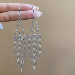 Vista detallada de elegantes pendientes geométricos de plata con borlas largas y circonitas