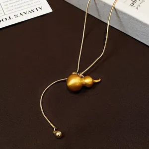 Macro shot of gold brushed gourd pendant on an adjustable snake chain necklace