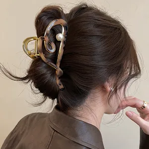 Detailed side view of a vintage leopard print heart-shaped hair claw clip with pearl accent