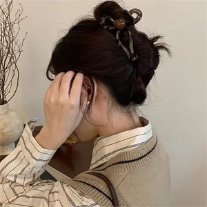 Detailed view of vintage leopard print hair claw clip with brown heart on model in a bun