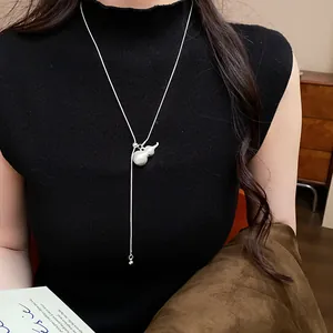Detail of a silver brushed gourd pendant on a stylish adjustable pull-style chain necklace.