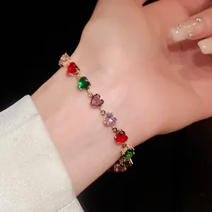 Gros plan détaillé d'un bracelet doré avec des zircons multicolores en forme de cœur
