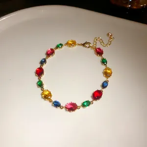 Gros plan de pierres de zircon ovales multicolores sur un bracelet plaqué or
