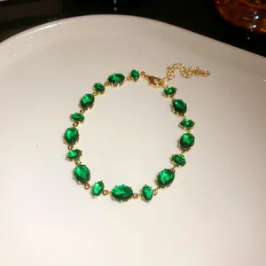 Gros plan détaillé d'un élégant bracelet doré orné de pierres ovales vert émeraude