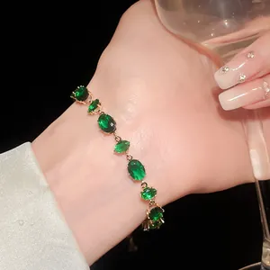 Détail d'un bracelet élégant en zircon vert ovale porté pour un look de soirée chic