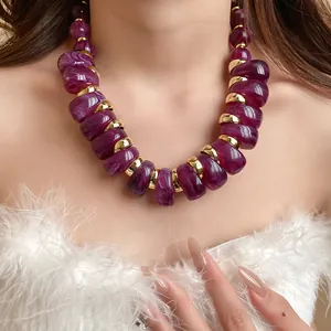 Primer plano detallado de collar de cuentas de acrílico morado y detalles dorados
