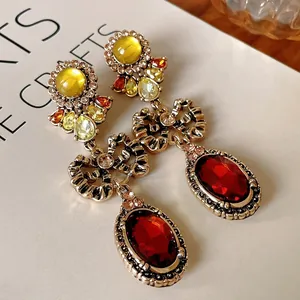 Retro bow-knot drop earrings featuring red oval stones and vintage gold-tone metal finish