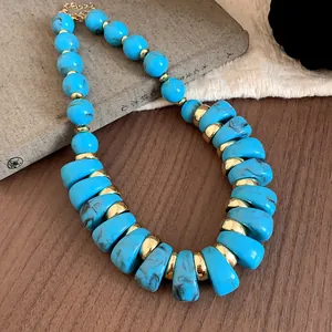 Primer plano detallado de cuentas de acrílico azul jaspeado y piezas doradas del collar