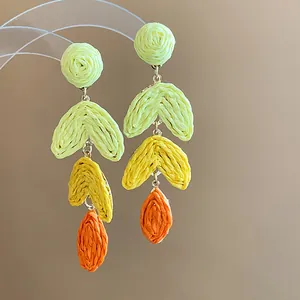 Detailed view showing the texture of colorful raffia woven earrings in boho gradient design