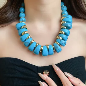 Primer plano de cuentas de acrílico azul turquesa y espaciadores dorados collar