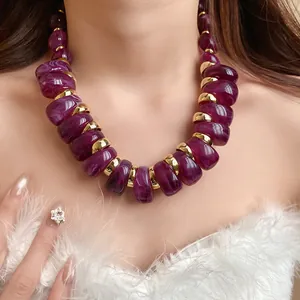 Primer plano de un collar de moda con cuentas gruesas de acrílico morado en el cuello