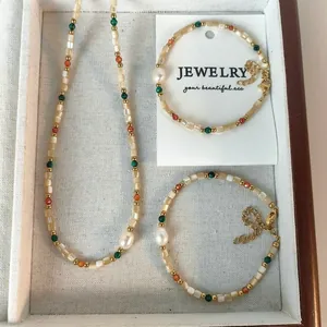 Elegante conjunto de joyas con collar y pulseras de perlas y conchas de colores