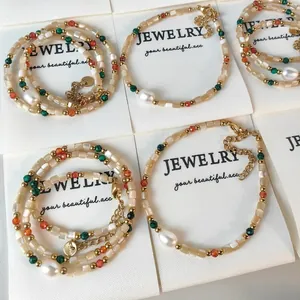 Elegante conjunto de collares de perlas y conchas de colores con detalles dorados
