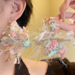 Primer plano de pendientes de flores de hilo hechos a mano con perlas