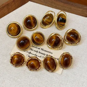 Variety of vintage gold-plated resin stud earrings in Maillard brown tones.