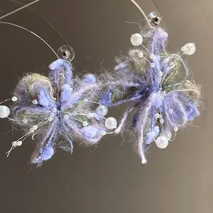 Primer plano macro que muestra la textura suave de los pendientes de flores de lana violeta