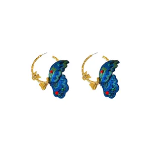 Elegant gold hoop earrings featuring intricate blue embroidered butterflies.