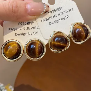 Elegant gold-plated stud earrings with brown resin cat-eye stones on display cards