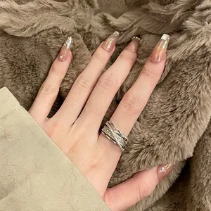 Detailed close-up showing a multi-layer crisscross ring with zircon pavé on a finger