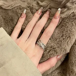 Close-up of a silver multi-layer cross ring with sparkling zircon details on a hand.