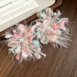Detalle de cerca de pendientes de flores de lana con perlas sobre agujas de plata