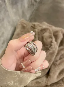 Detail shot of a layered silver-tone ring with sparkling zircon pavé on a hand