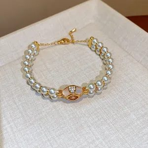 Detailed macro view of a luxury double-strand pearl bracelet with zircon centerpiece