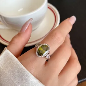 Elegante anello con zircone verde oliva ovale con alone scintillante e design traforato