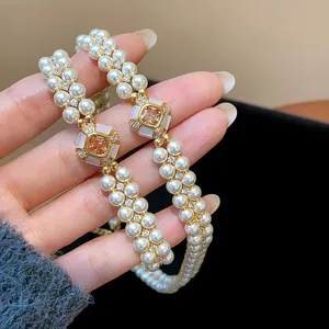 Detailed view of elegant double-row pearl bracelet with champagne zircon centerpiece.