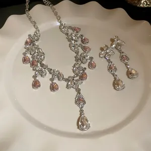 Parure collier et boucles d'oreilles élégante avec gouttes de cristal roses.